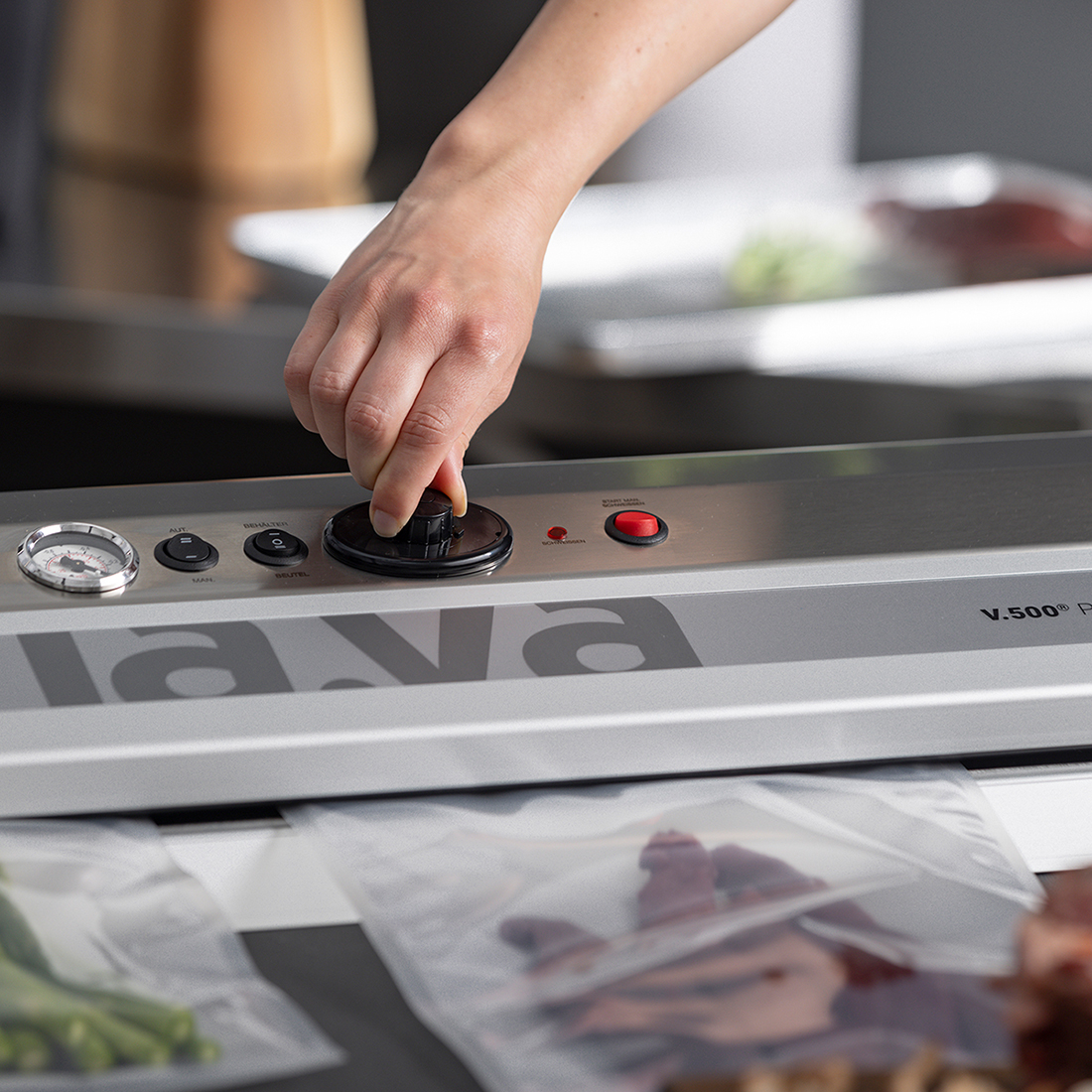V.500 Premium vacuum sealer during the vacuum sealing process, with one hand operating the pressure control