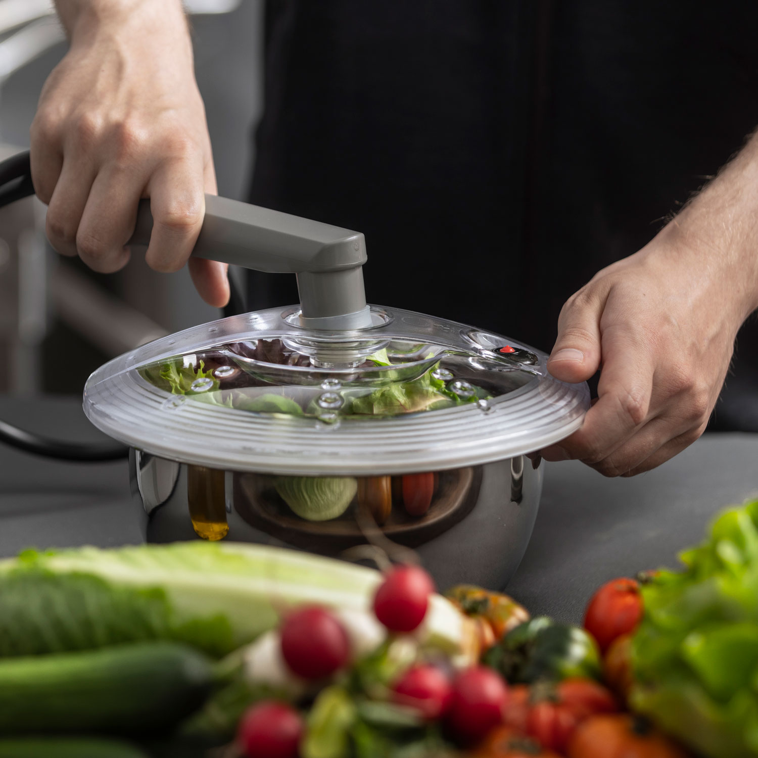 Salat wird im Vakuumbehälter aus Edelstahl mithilfe der Absaugvorrichtung vakuumiert