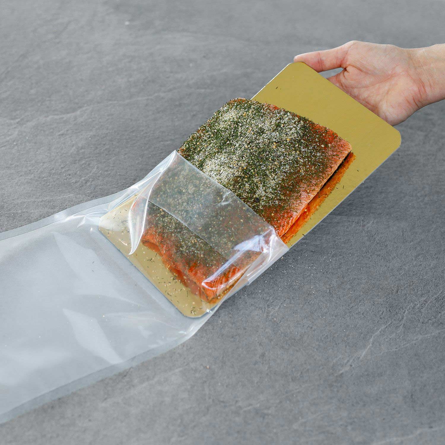 Gravlax is placed with a seasoning mixture into a vacuum bag