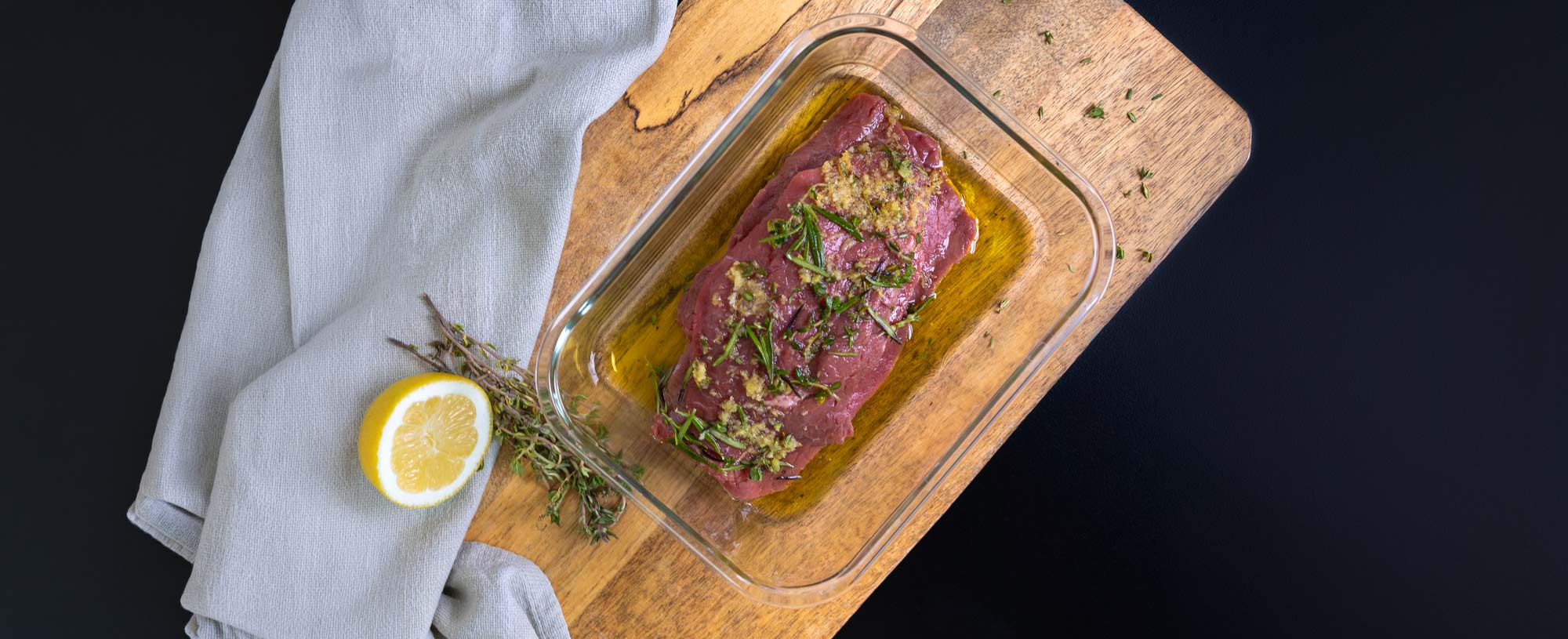 Rohes Rinderfilet im G-Line Glasbehälter mit Ölmarinade mit frischen Kräutern, Knoblauch und Zitrone