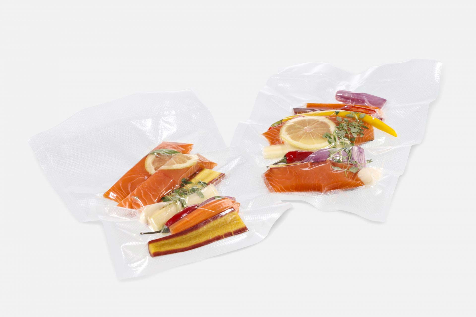 Two structured transparent vacuum bags vacuum-sealed with food for vacuum cooking