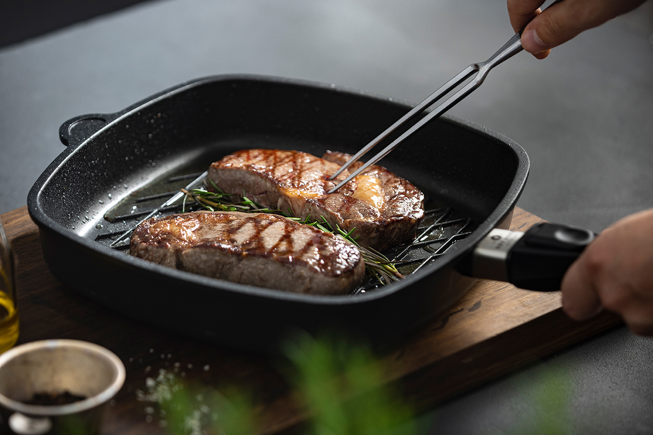 Two steaks that were previously cooked sous-vide are being seared in a pan