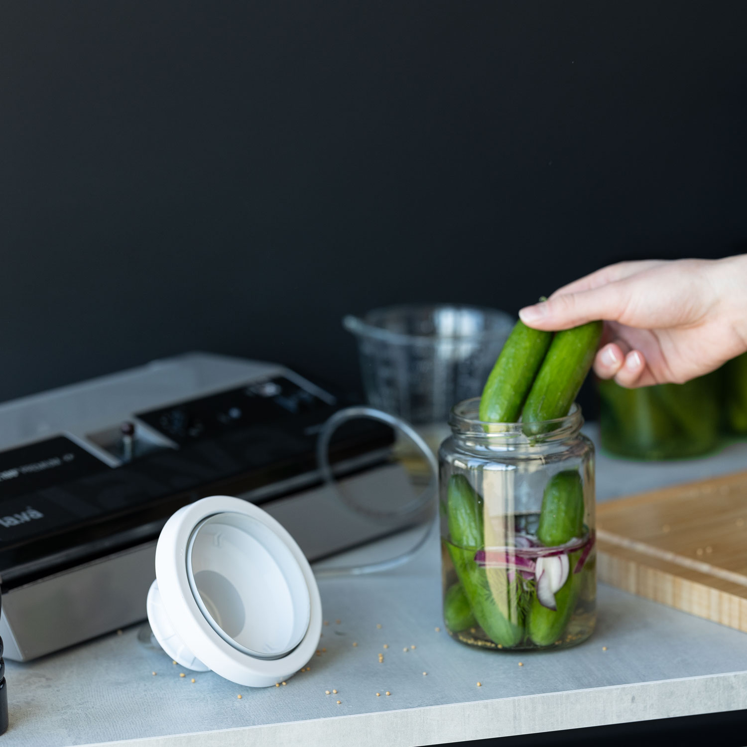 Cucumbers are placed in a preserving jar to make pickles using a vacuum sealer