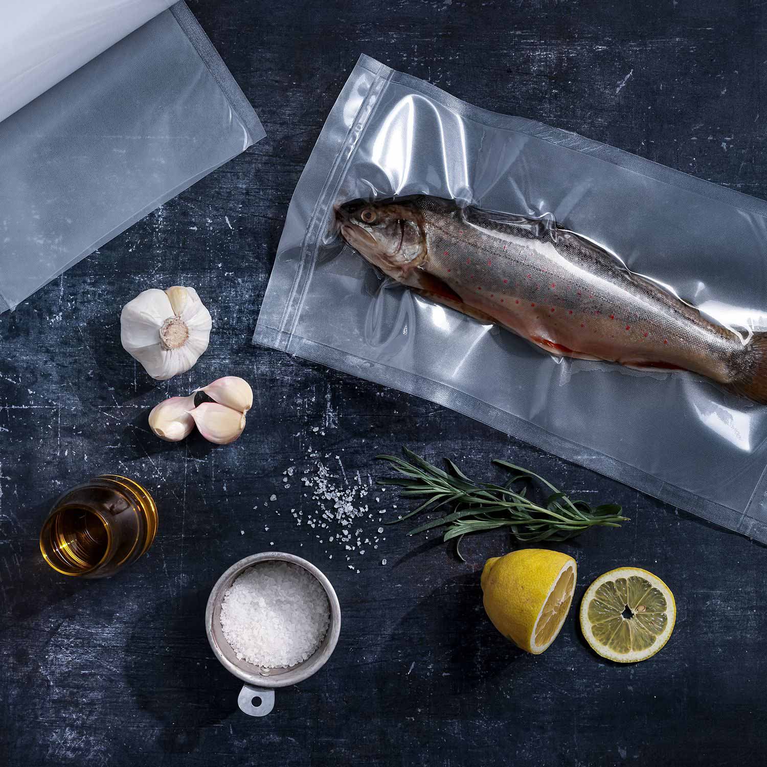 Structured vacuum roll next to it vacuum-sealed trout in a vacuum bag 