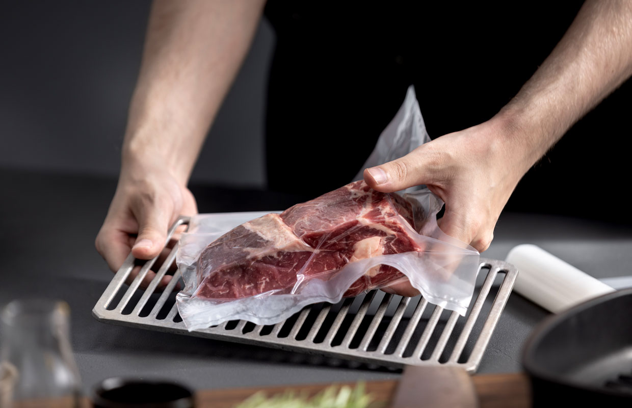 Vakuumbeutel wird auf Gitterrost im Kühlschrank gelegt, damit das Fleisch reifen kann