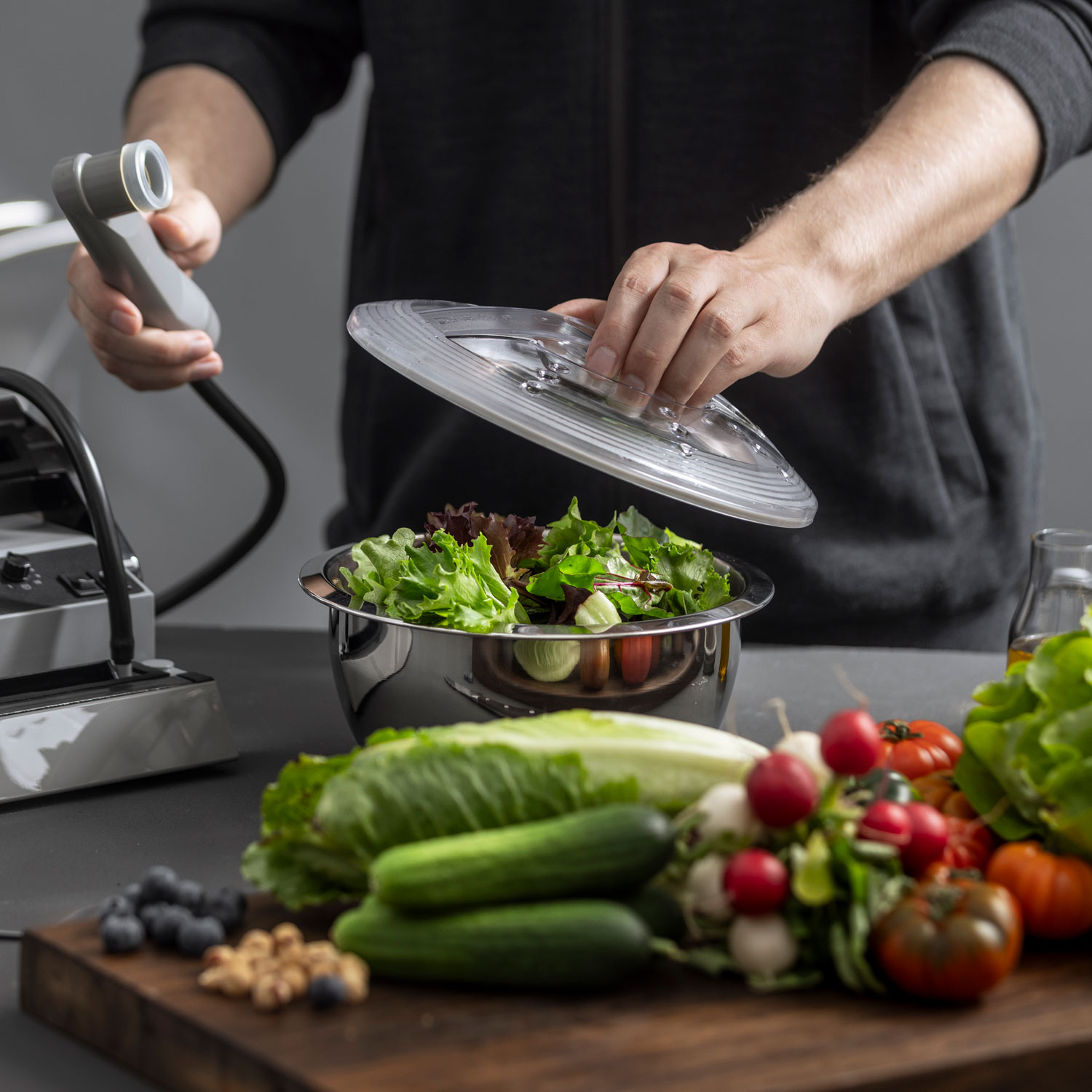 Stainless steel vacuum container has a lid placed on top before it can be vacuum-sealed using the suction device