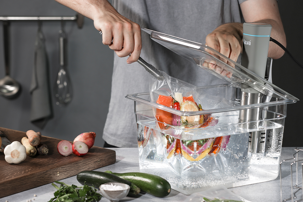 Sous Vide Stick gart vakuumiertes Gemüse und Fisch in einem Wasserbad