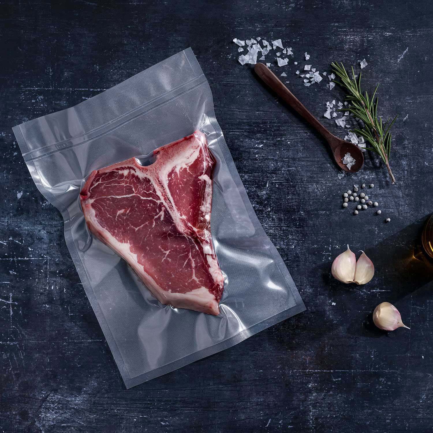 Transparent structured vacuum bag with T-Bone steak vacuum-sealed