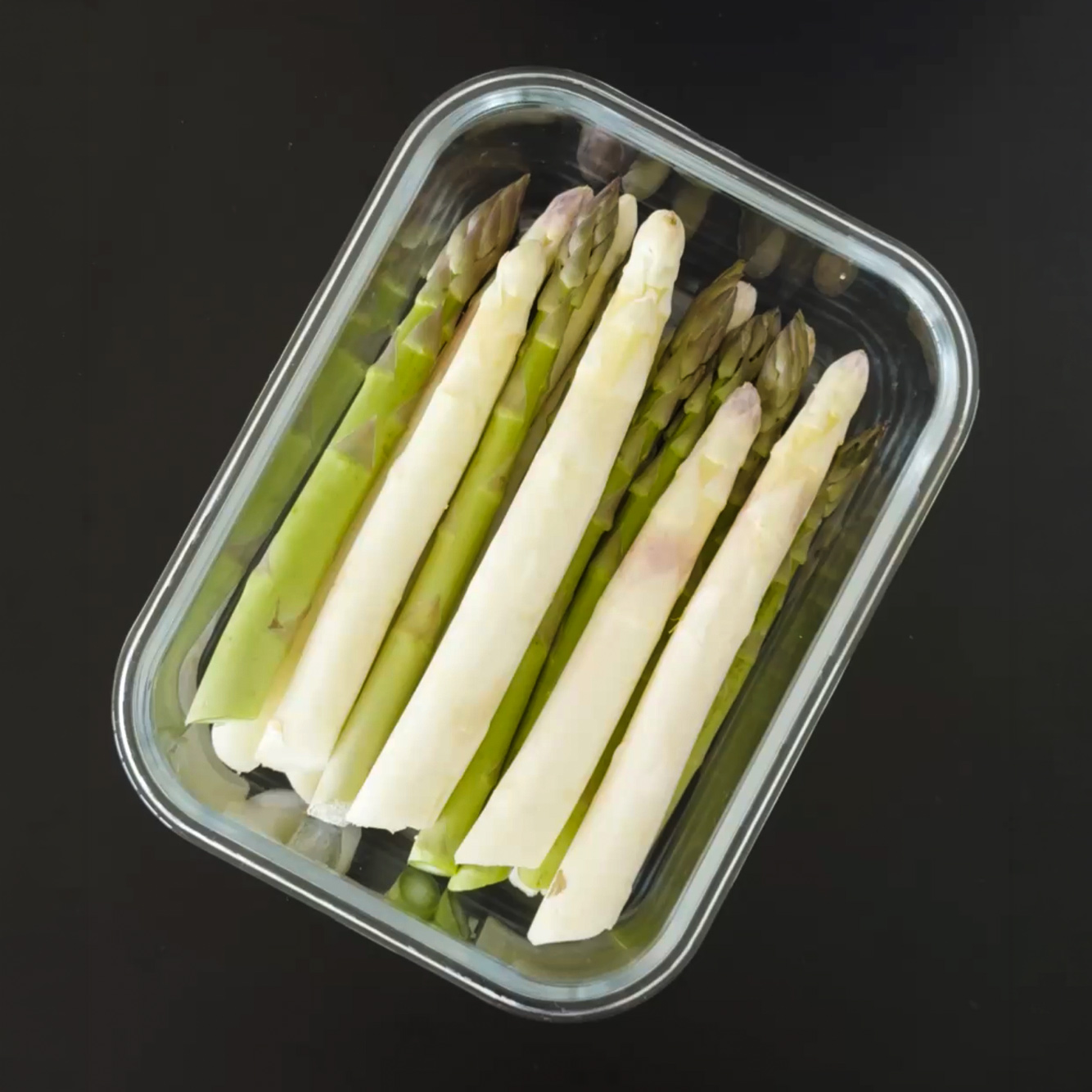 Weißer und grüner Spargel liegen frisch gewaschen im G-Line Glasbehälter.